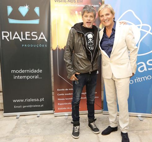 Dois convidados junto ao painel da Rialesa Produções